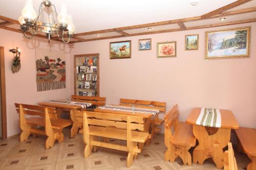 a dining room with wooden tables and chairs at АртГір гостинний двір in Mykulychyn
