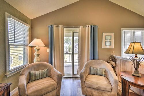 a living room with two chairs and a table and windows at Home with Deck in Corolla Light Walk to Beach! in Corolla