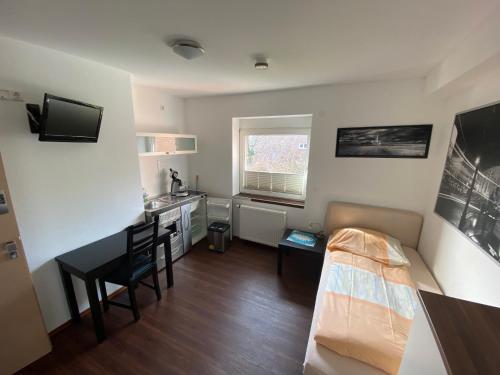Kleines Zimmer mit einem Bett und einem Schreibtisch. in der Unterkunft Pension Haselmann in Münster