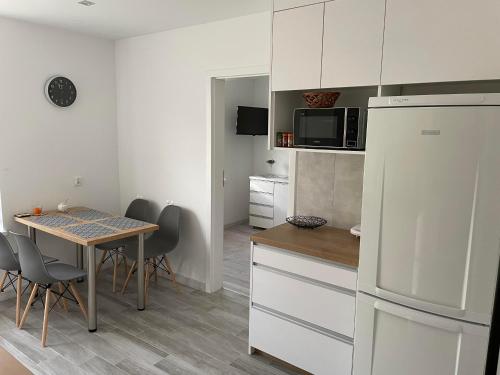 a kitchen and dining room with a table and a refrigerator at Na Końcu Świata in Pozezdrze