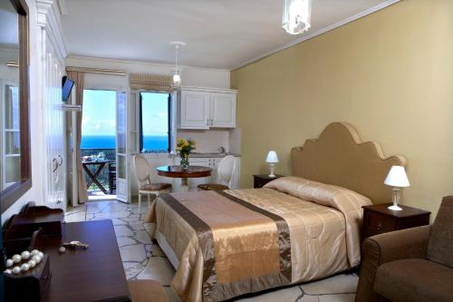 a bedroom with a bed and a living room with a table at Dafnoudi Hotel Apartments in Fiskardo