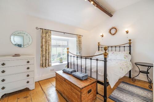 a bedroom with a bed and a dresser at Pye Hall Cottage in Silverdale