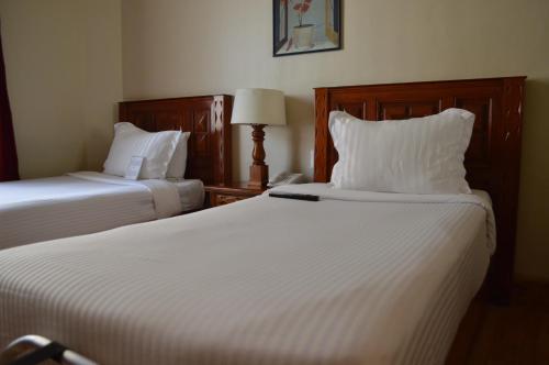 a hotel room with two beds with white sheets at Best Western Majestic in Mexico City