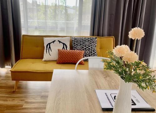 奧克蘭的住宿－Auckland Central Motel，客厅配有黄色的沙发和桌子