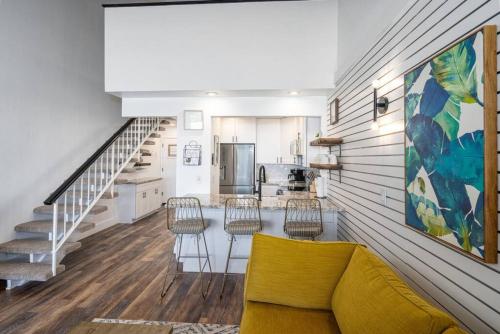 a living room with a yellow couch and a kitchen at Modern-Rustic Beach Renovation Direct Oceanfront Penthouse in Kahana