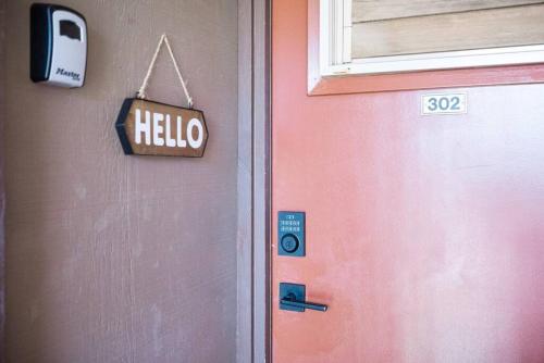 a door with a hello sign next to a house at Modern-Rustic Beach Renovation Direct Oceanfront Penthouse in Kahana