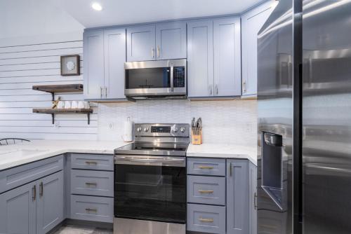 カハナにあるDirect Oceanfront Views Modern Penthouse in Paradiseのキッチン(白いキャビネット、ステンレス製の電化製品付)