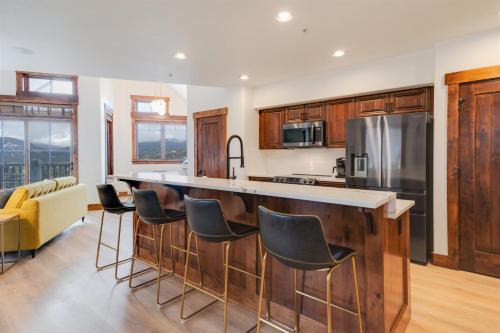 ブリッケンリッジにあるModern Breckenridge Penthouse Ski In Ski Outのバースツール付きの大きな島のあるキッチンが備わります。