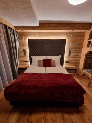 a bedroom with a large bed with a red blanket at Panorama Berg Chalet in Großkirchheim