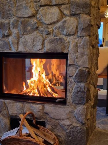 a stone fireplace with a fire in it at Panorama Berg Chalet in Großkirchheim