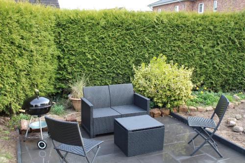 a patio with a grill and chairs and a barbecue at Mimi's Ostseeglück in Grömitz