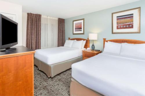 a hotel room with two beds and a flat screen tv at Sonesta ES Suites Atlanta Perimeter Center in Atlanta