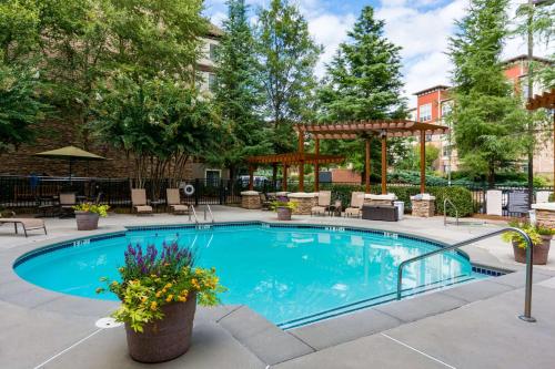 a swimming pool with a pergola next to a building at Sonesta ES Suites Atlanta Perimeter Center in Atlanta