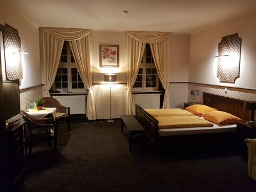 a bedroom with two beds and a table and chairs at Gotikhotel Frenzelhof in Görlitz