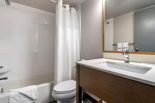 a bathroom with a sink and a toilet and a mirror at Best Western Plus Vancouver Airport Hotel in Vancouver
