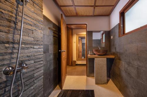 y baño con lavabo y ducha. en Tattva Ubud Retreat & Wellness en Ubud