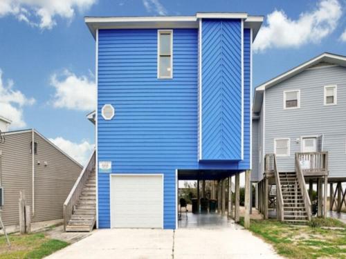 una casa azul con una puerta blanca en una calle en Sea Haven - OCEANFRONT! Amazing master suite with a private oceanfront deck! Recently renovated and perfect for the entire family home, en Kure Beach