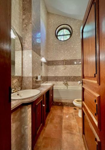 a bathroom with a sink and a tub and a toilet at Villa Bouro - Breathtaking scenery near Gerês in Terras de Bouro