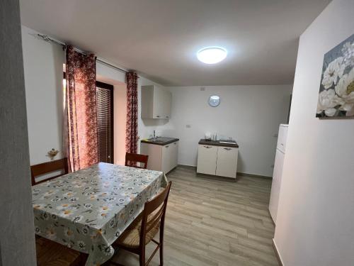 eine Küche und ein Esszimmer mit einem Tisch und Stühlen in der Unterkunft Al Vicolo Casa Vacanze - Casa “Castello” in Roccadaspide