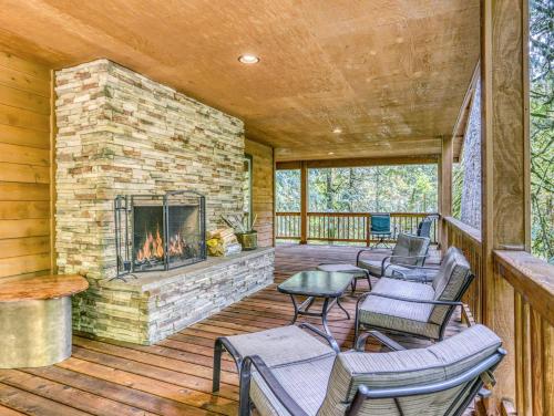 a living room with a fireplace on a deck at Barlow Trail Lodge - Meredith Lodging in Rhododendron
