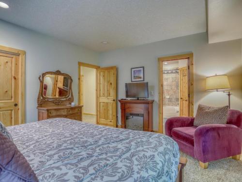 a bedroom with a bed and a chair and a mirror at Barlow Trail Lodge - Meredith Lodging in Rhododendron