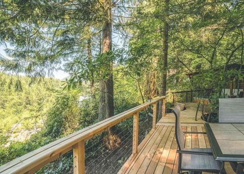 a wooden deck with a table and chairs on it at River View Cabin - Meredith Lodging in Welches