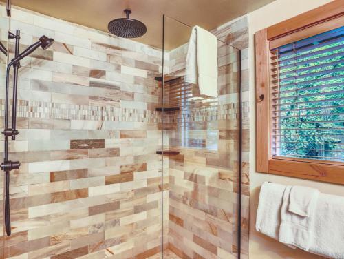 a bathroom with a walk in shower next to a window at River View Cabin - Meredith Lodging in Welches