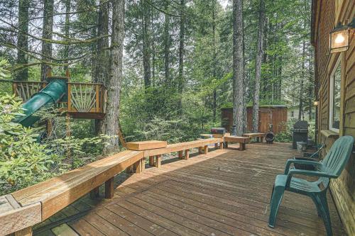a wooden deck with benches and a slide in the woods at River Breeze Chalet - Meredith Lodging in Rhododendron