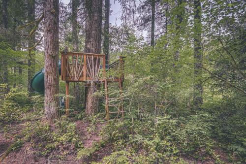 a wooden playground in the middle of a forest at River Breeze Chalet - Meredith Lodging in Rhododendron