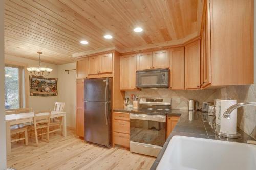 a kitchen with wooden cabinets and a stainless steel refrigerator at River Breeze Chalet - Meredith Lodging in Rhododendron