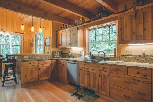 a kitchen with wooden cabinets and a sink and a stove at Cedar Springs Cabin - Meredith Lodging in Welches
