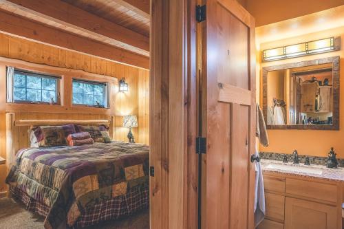 a bedroom with a bed and a sink and a mirror at Cedar Springs Cabin in Welches