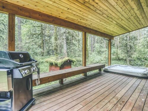 a screened in porch with a bbq and a grill at Ripplewood - Meredith Lodging in Welches