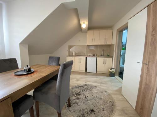 a kitchen and dining room with a wooden table and chairs at Koca Apartmani in Novi Pazar