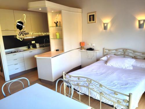 une petite chambre avec un lit et une cuisine dans l'établissement Studio 4 pers Piscine Chauffée accès à pied à la plage Santa Giulia, à Porto-Vecchio