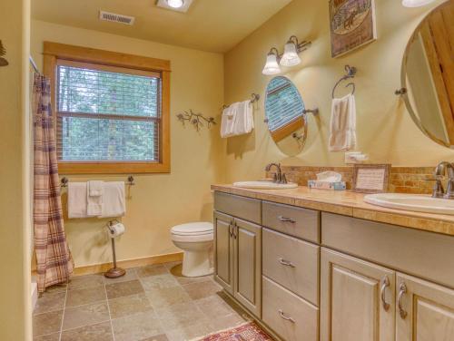 a bathroom with two sinks and a toilet and a window at Zigzag Mountain Lodge - Meredith Lodging in Rhododendron