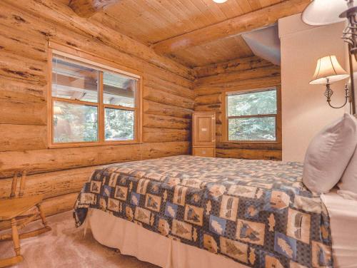 - une chambre avec un lit dans une cabane en rondins dans l'établissement Bear Den Log Cabin, à Welches