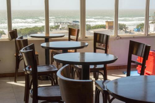 a restaurant with tables and chairs and a view of the ocean at Hotel Paucam in Santa Teresita