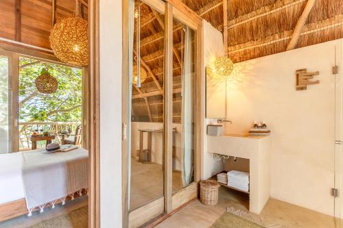 a room with a bathroom with a sink and a window at Ahau Tulum - Beachfront Hotel in Tulum