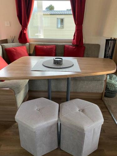 a wooden table with two stools in a living room at Deluxe 3 bedroom caravan in Haven's Seton Sands Holiday Village,Wifi in Port Seton