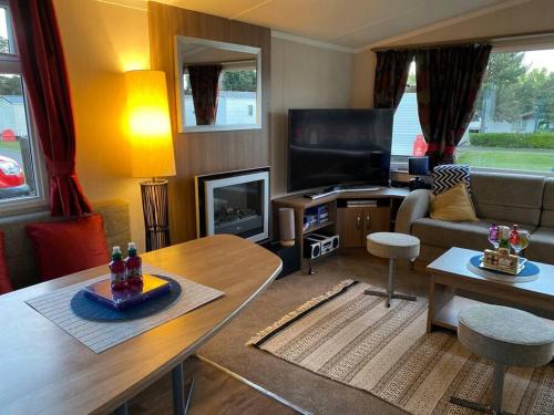 a living room with a couch and a table at Deluxe 3 bedroom caravan in Haven's Seton Sands Holiday Village,Wifi in Port Seton