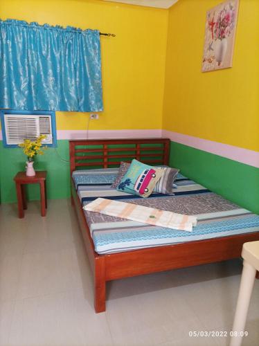 a bedroom with two beds and a yellow wall at Jay Henry Transient Beach house , A Pagudpud ,BLUE LAGOON BEACH in Pagudpud