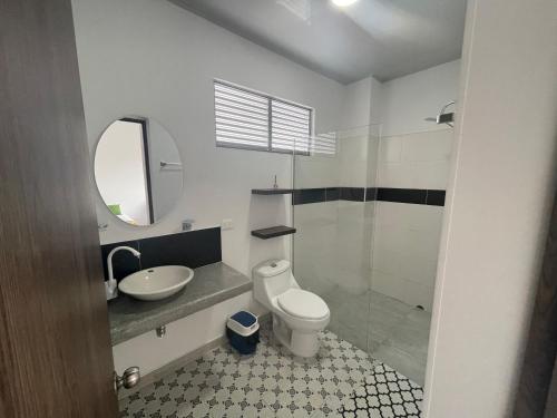 a bathroom with a sink and a toilet and a mirror at Villa Tokyo in Ibagué