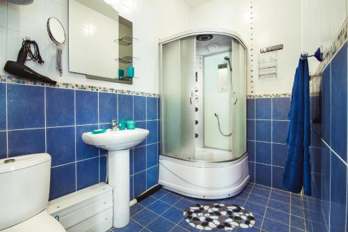 Yal Hotel في كازان: حمام ازرق وابيض مع مرحاض ومغسلة