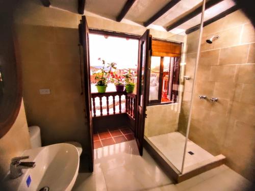 baño con lavabo y ducha con ventana en Hostal Boutique Nariño Plaza, en Villa de Leyva