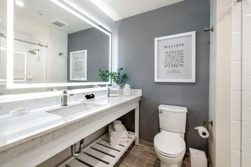 a bathroom with a sink and a toilet and a mirror at Cambria Hotel Calabasas - Malibu in Calabasas