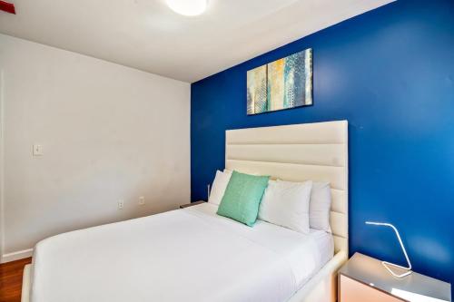 a bedroom with a white bed with a blue wall at Stylish & Great location next to the convention center in Philadelphia