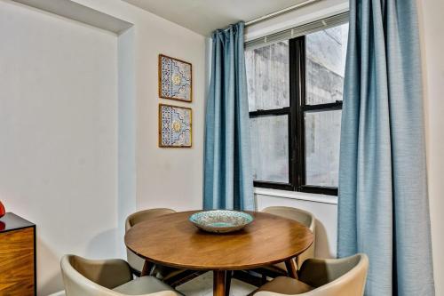 comedor con mesa, sillas y ventana en Bee Home in the City en Filadelfia