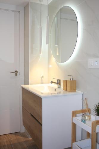 La salle de bains est pourvue d'un lavabo et d'un miroir. dans l'établissement Apartamentos La Herradura Viñas, à Haro