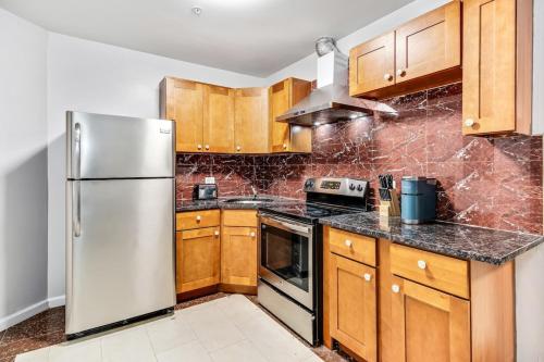 a kitchen with wooden cabinets and a stainless steel refrigerator at Spacious&stylish 2bd apt with great location! in Philadelphia